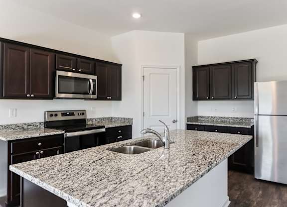 A kitchen with granite countertops and stainless steel appliances.