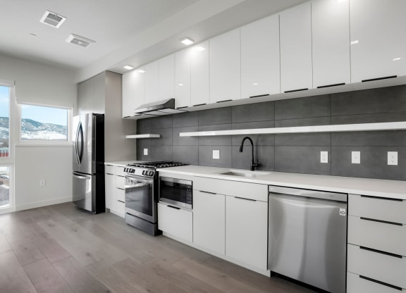 a kitchen with white cabinets and stainless steel appliances