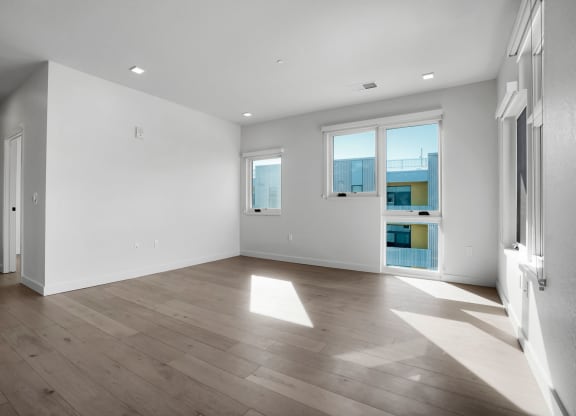 a bedroom with hardwood floors and white walls