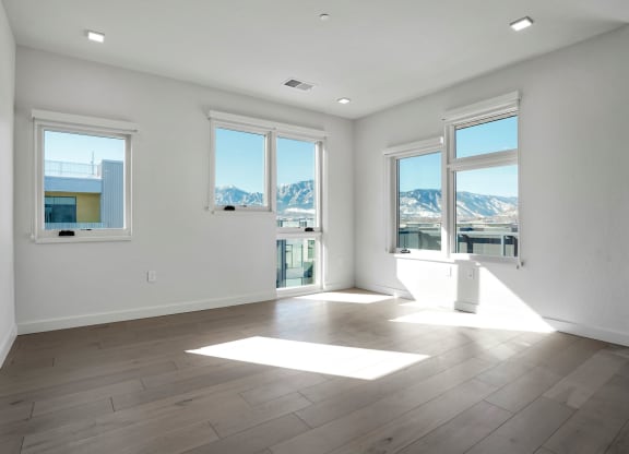 a bedroom with hardwood floors and white walls