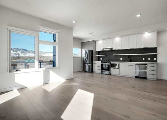 an open kitchen and living room with a large window and a view of a mountain