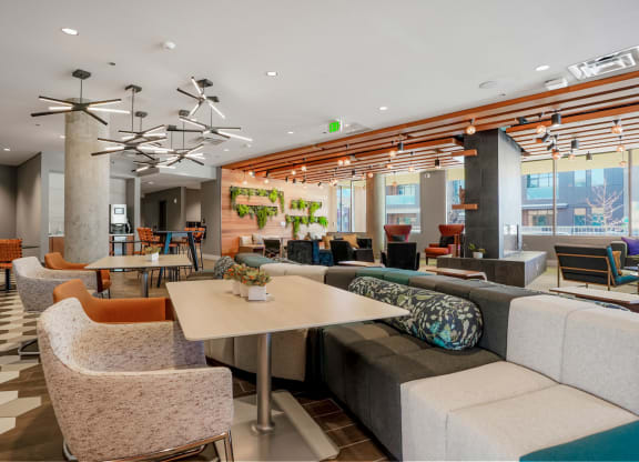 a seating area with couches tables and chairs and a chandelier