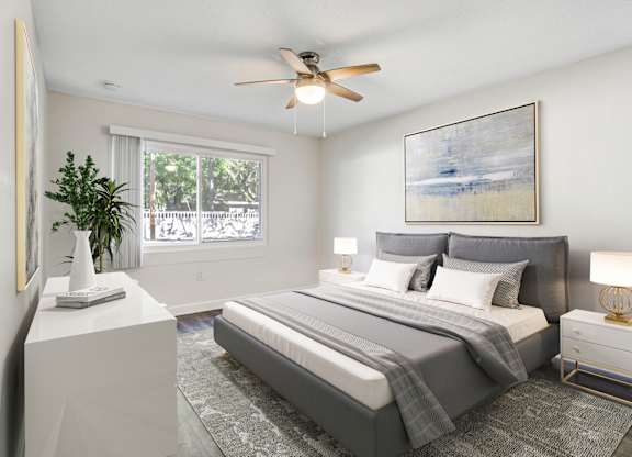 Bedroom with large window, natural light, and ceiling fan at Square One Apartments in Gainesville FL