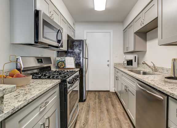 Kitchen with stainless steel appliances and ample cabinet space at Square One Apartments in Gainesville FL