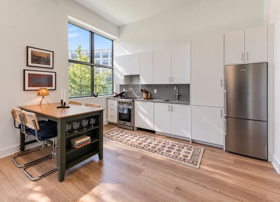 A kitchen with white cabinets and a wooden island.