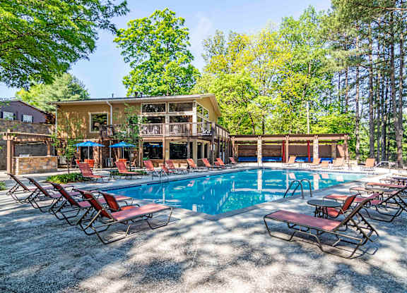 Resort-style swimming pool with lounge chairs and shaded seating at pet-friendly Stratford Ridge Apartments in Marietta, GA, perfect for relaxation and socializing.