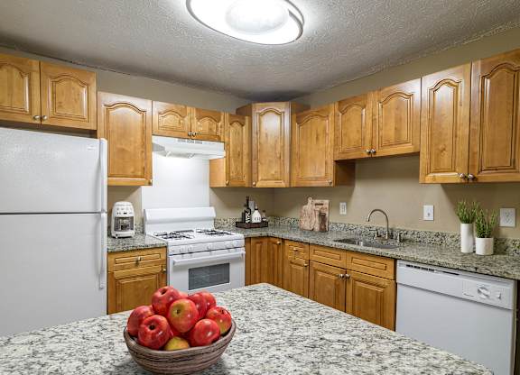 Kitchen at Stratford Ridge Apartments in Marietta, GA, showcasing warm wooden cabinets and clean white appliances, offering a bright and functional cooking space.