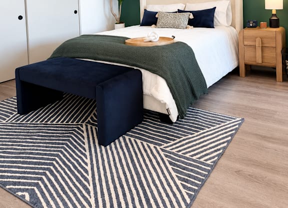 A bedroom with a bed, nightstand, and a ceiling fan.