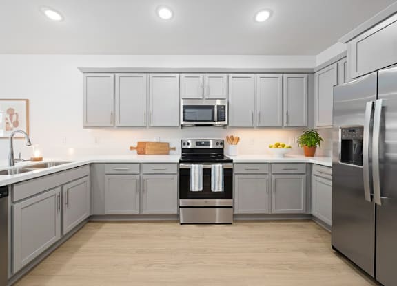 A modern kitchen with stainless steel appliances and wooden floors.