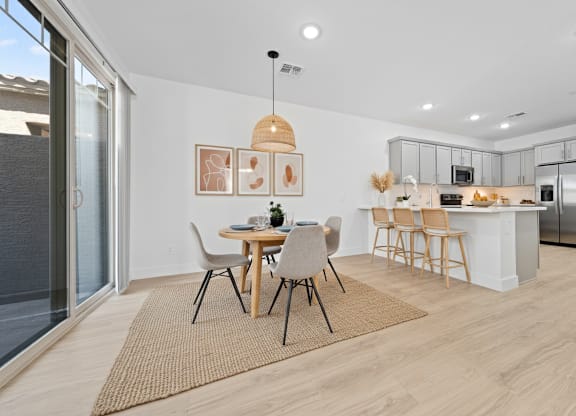 A modern kitchen with a dining table set for four.