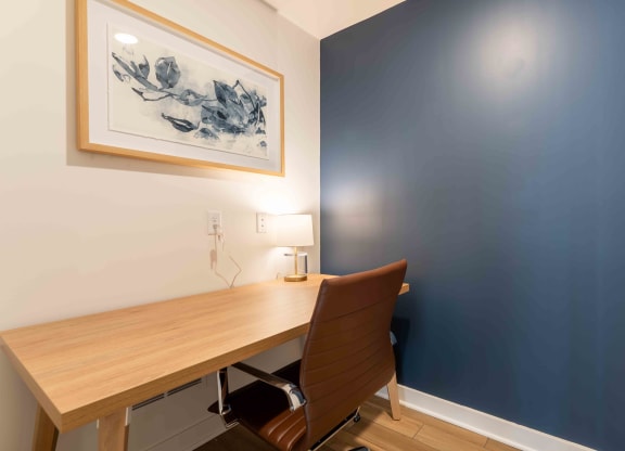 a home office with a wooden desk and a blue wall