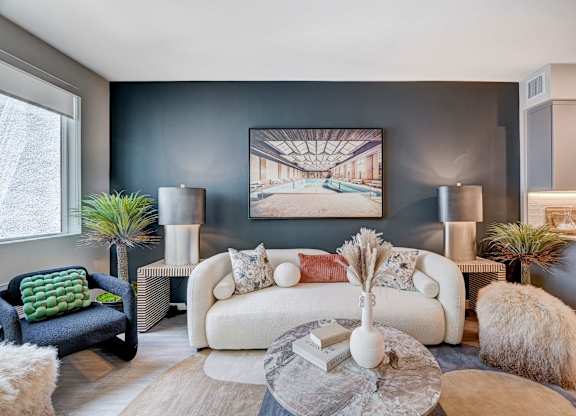A modern living room with a large painting on the wall and a white sofa.