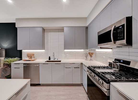 A modern kitchen with a black countertop and white cabinets.