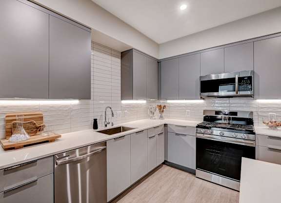 A modern kitchen with stainless steel appliances and wooden countertops.