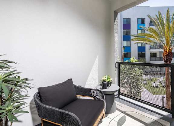 A balcony with a chair and a table.