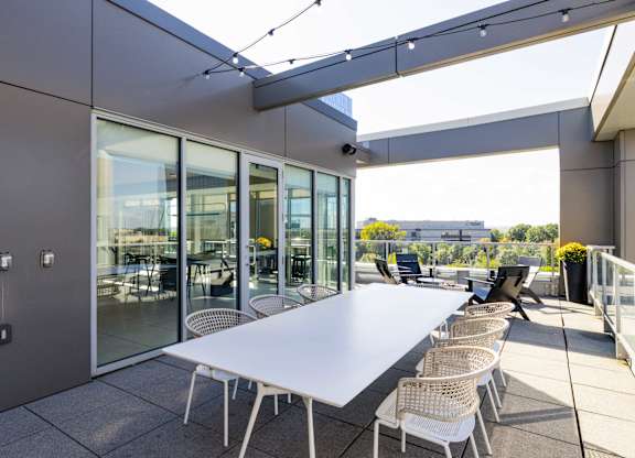 A white table with chairs is set up on a patio.
