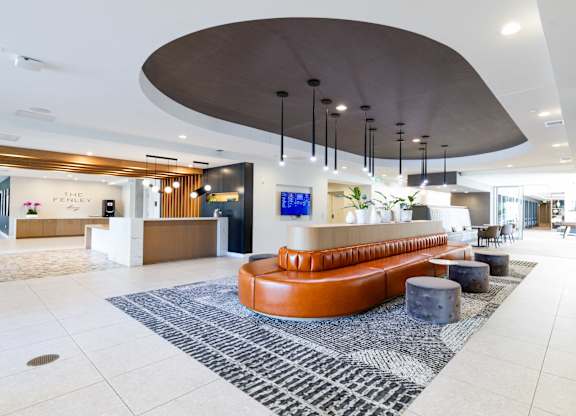 A reception area with a curved ceiling and a long orange couch.