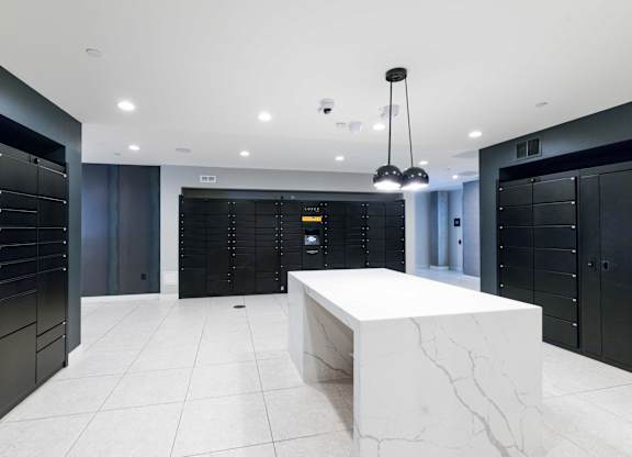 A white marble table is in the middle of a room with black lockers on the walls.