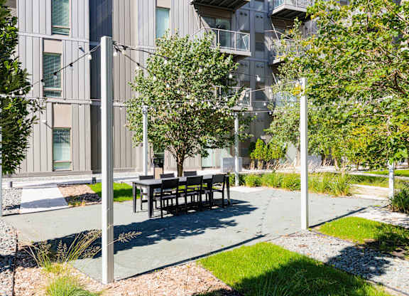 A modern building with a tree and bench in front.