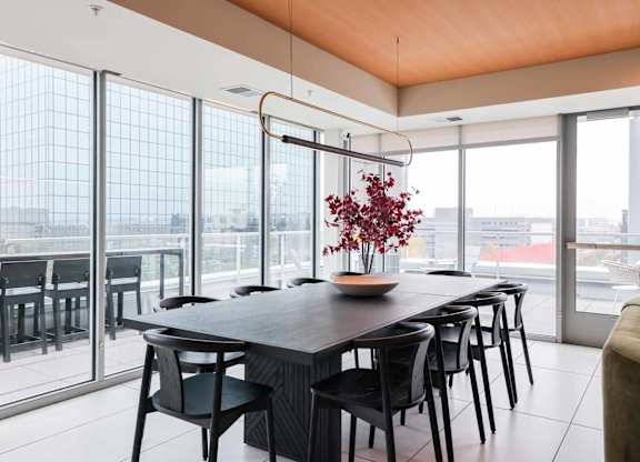 A modern dining room with a long table and chairs.