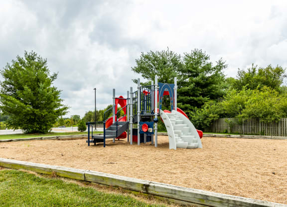 a playground with a slide and climbing equipment in a park