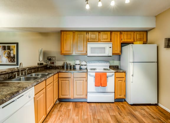 a kitchen with white appliances and wooden cabinets