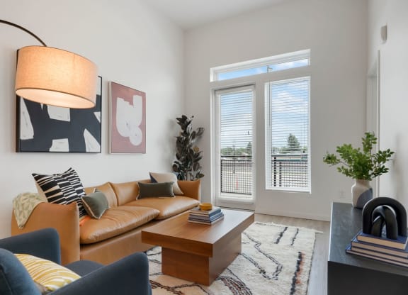 2-BR Apartments in Wheat Ridge, CO - Parallel - Living Room with Couch, Chair, Area Rug, Coffee Table, Large Window, Luxury Plank Flooring.