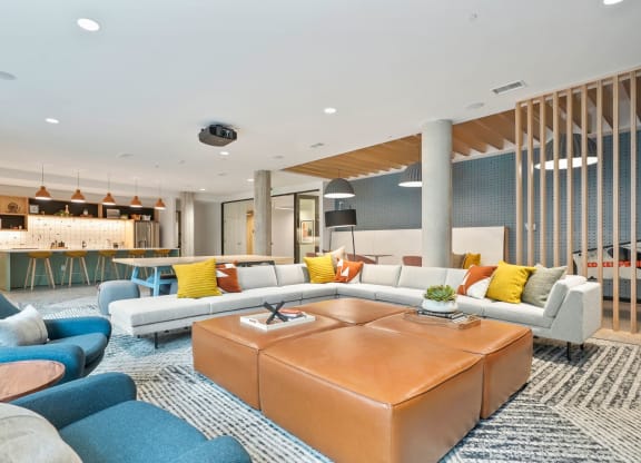 Apartments For Rent In Wheat Ridge, CO - The Parallel - Clubroom With Chef’s Kitchen, TV Lounge, Game Area, Couches, Lounge Chairs, and Screen Projector