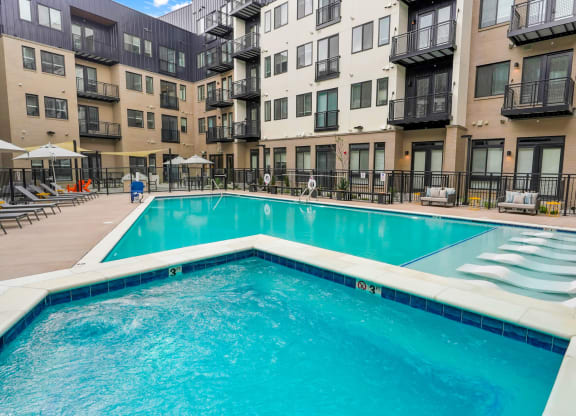 a swimming pool in front of an apartment building
