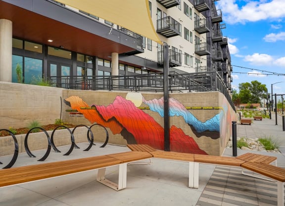 a bench with a mural on the side of a building