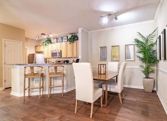 Apartments in Opelika for Rent – The Crossings of Opelika - a dining area with a table and chairs and a kitchen in the background