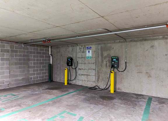 Two electric vehicle charging stations in a parking garage.