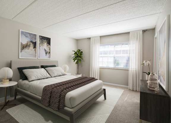 Bedroom with plush carpet, large window, and good natural lighting at Townsend Apartments in Jacksonville near Atlantic Beach, Florida