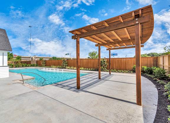 a backyard with a pool and a pergola