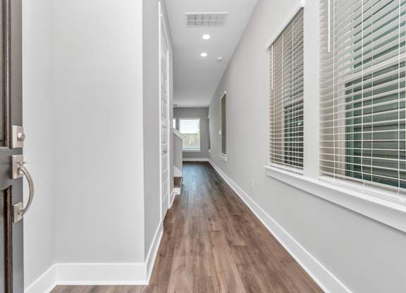 a hallway with hardwood floors and grey walls