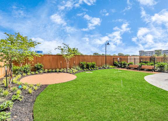 a backyard with green grass and a wooden fence