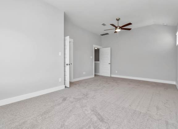Heights, Houston, TX, Rental Homes - The Crossing at Timbergrove - Spacious Bedroom with Carpet Flooring, and a High Ceiling with a Ceiling Fan.