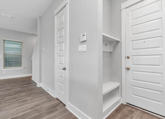 a walk in closet in a bedroom with a door to a closet and a window