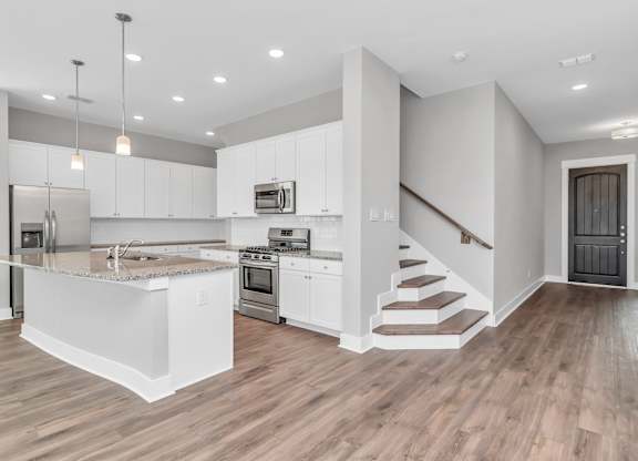 a kitchen with white cabinetry and a kitchen island with a granite countertop