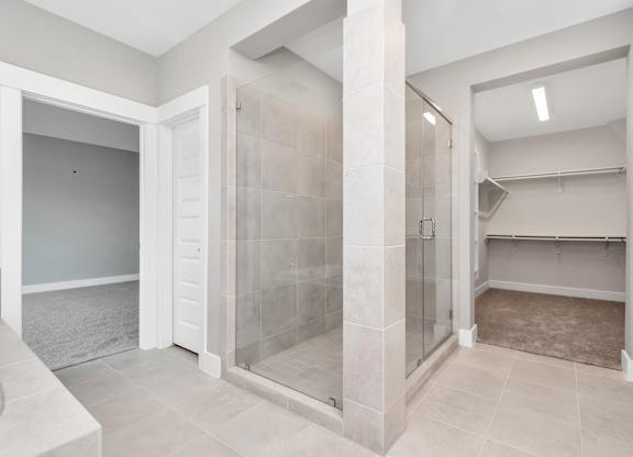 a large walk in shower with tiled walls and floors