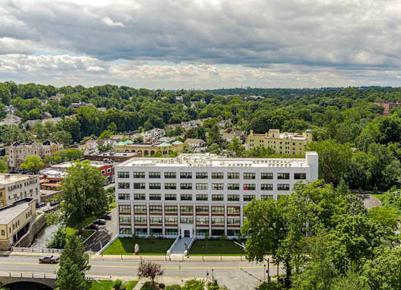 A large white building with a green lawn in front of it.