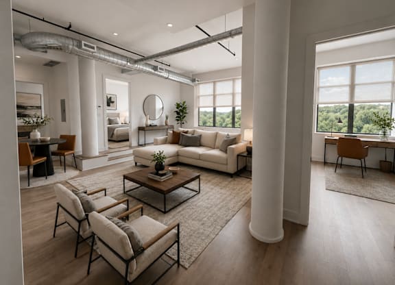A modern living room with a large window and a view of trees outside.