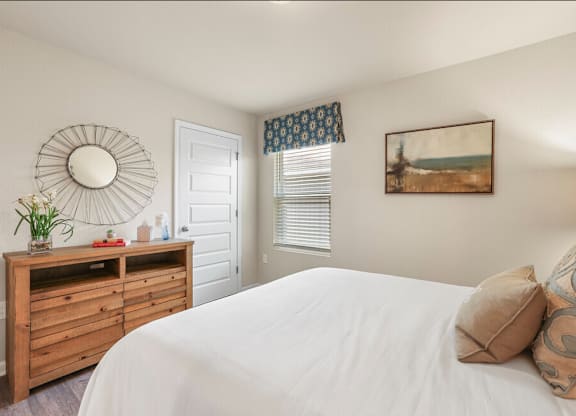 a bedroom with a bed and a dresser with a mirror
