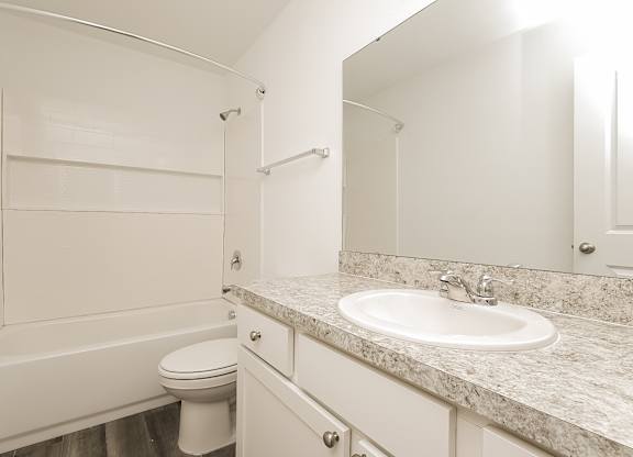 A white bathroom with a sink, toilet, and bathtub.