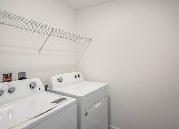 A white laundry room with a washer and dryer.