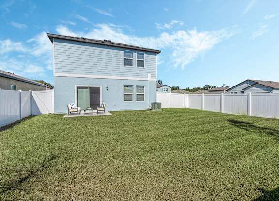 A house with a white fence and a green lawn.