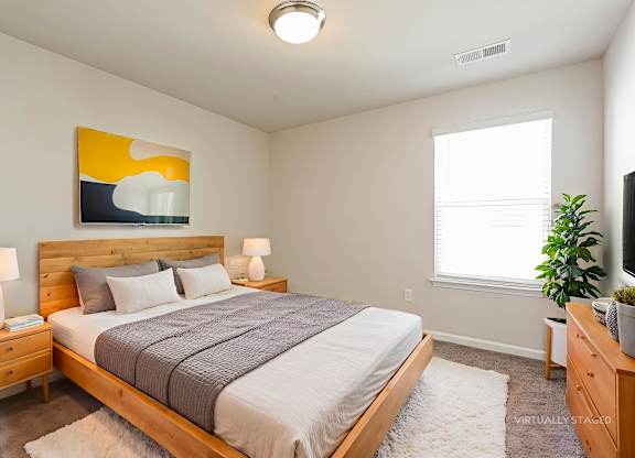 A bedroom with a bed, nightstands, and a painting on the wall.