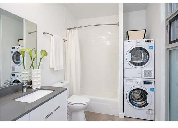 Apartments For Rent Fremont, WA - Inspire Frmont - Bathroom With A Garden-Style Tub, High Ceilings, And An In-Unit Washer And Dryer.