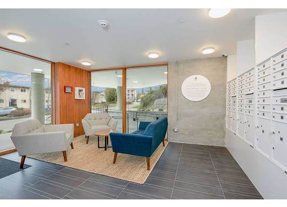 Apartments in Seattle, WA - Inspire Fremont - Lobby with Mail Slots, Floor-to-Ceiling Windows, and a Seating Area