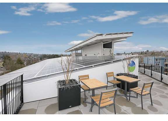 Apartments in Fremont, WA for Rent - Inspire Fremont - Rooftop with Solar Panels, Outdoor Seating, and View of the City